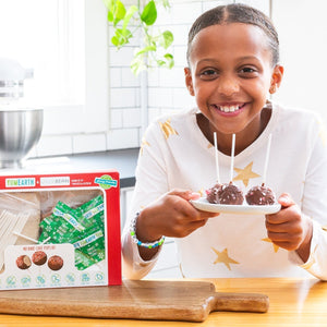 girl smiling while holding YumEarth no-bake cake pops kit