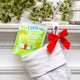 YumEarth sour littles pack peeking out of a white holiday stocking with red bow on a mantel.