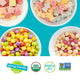 Bowls of YumEarth candy on a blue background with allergy-friendly and non-GMO icons.