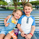 Kids enjoying YumEarth ultimate lollipops on a park bench
