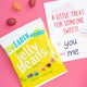 Yellow YumEarth Jelly Beans pack next to a Valentine’s card and jelly beans scattered on pink.