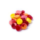 Pile of YumEarth fruit snacks in assorted shapes and colors on a white background